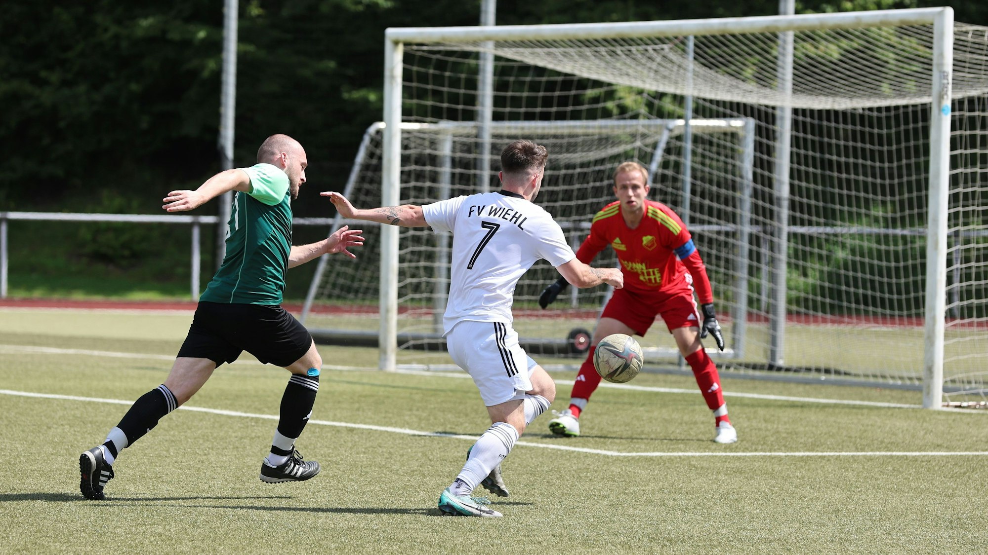 Der Wiehler Spieler mit der Nummer 7 läuft mit dem Ball am Fuß auf den Bergneustädter Torhüter zu.