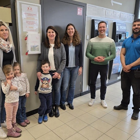 Frauen, Männer und Kinder stehen in einer Aldi-Filiale neben einem Pfandautomaten.