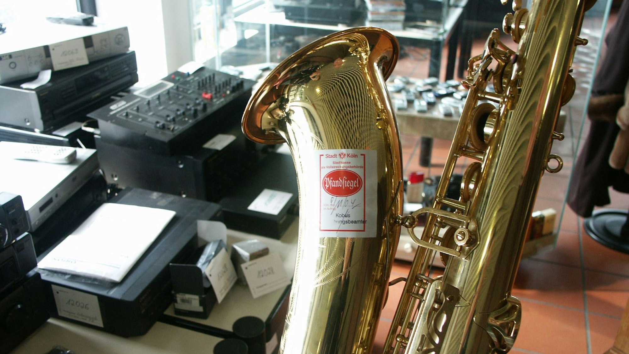 In einem Raum liegen gepfändete Gegenstände, darunter ein Saxophon