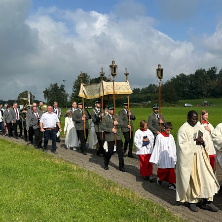Katholische Geistliche führen eine Prozession an.