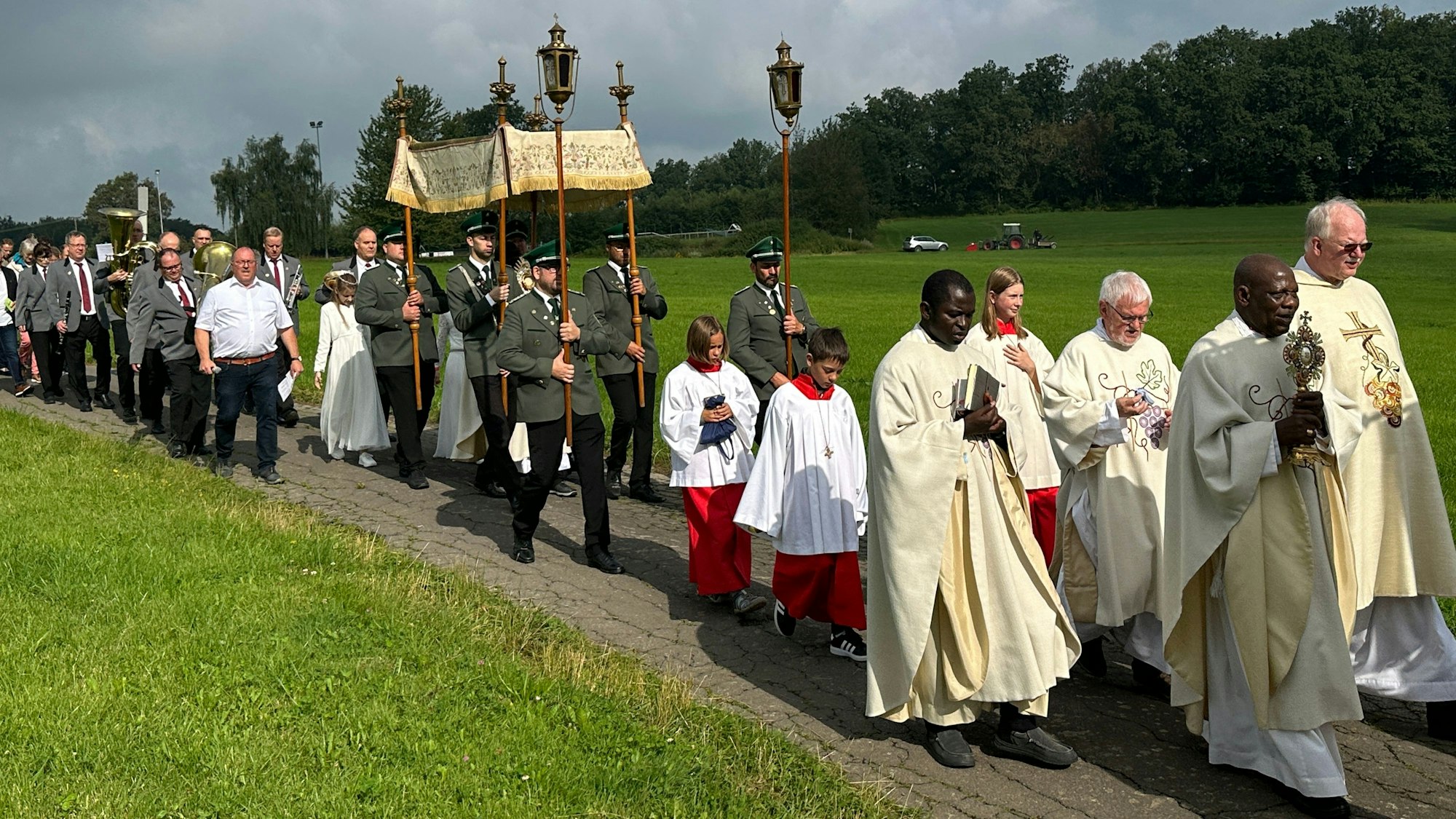 Katholische Geistliche führen eine Prozession an.