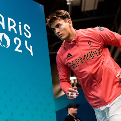 Im Outfit der deutschen Nationalmannschaft läuft Julian Köster vorbei an der Aufschrift Paris 2024 in die Halle ein.