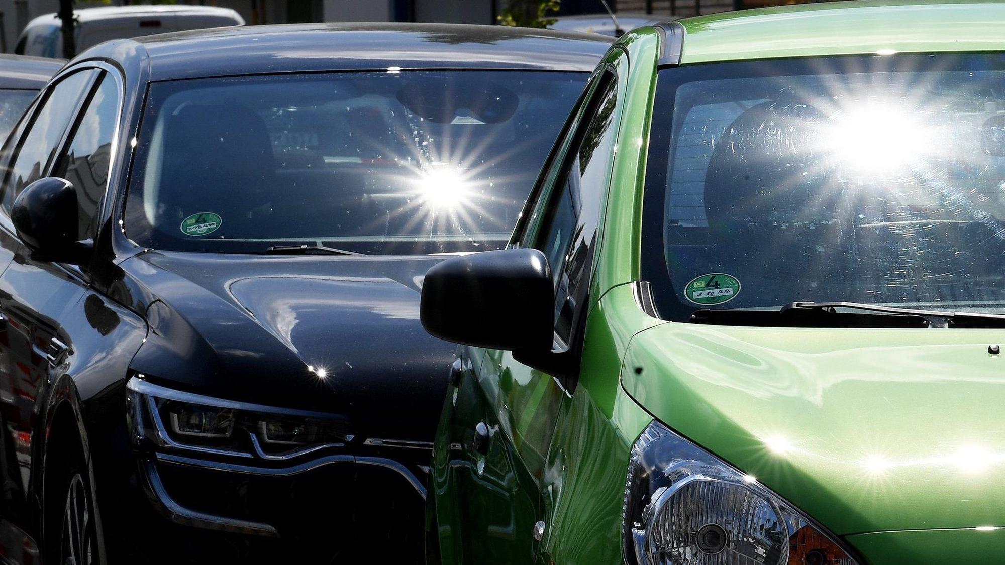 Sonne scheint auf parkende Autos.