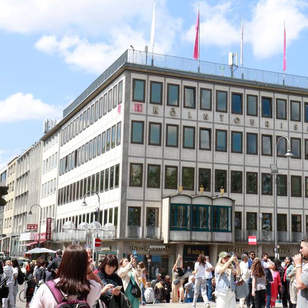 Zu sehen ist das Gebäude von Köln-Tourismus in der Altstadt. Davor stehen viele Menschen.
