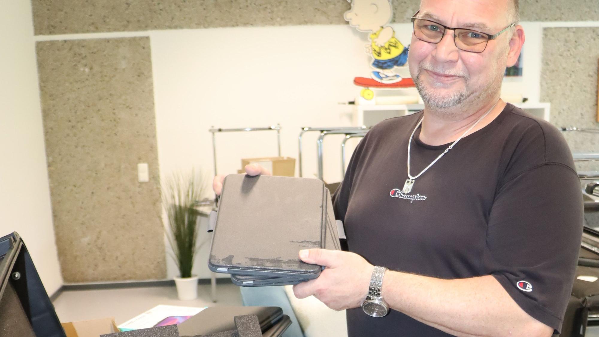 Ein Mann hält Tablets in den Händen.