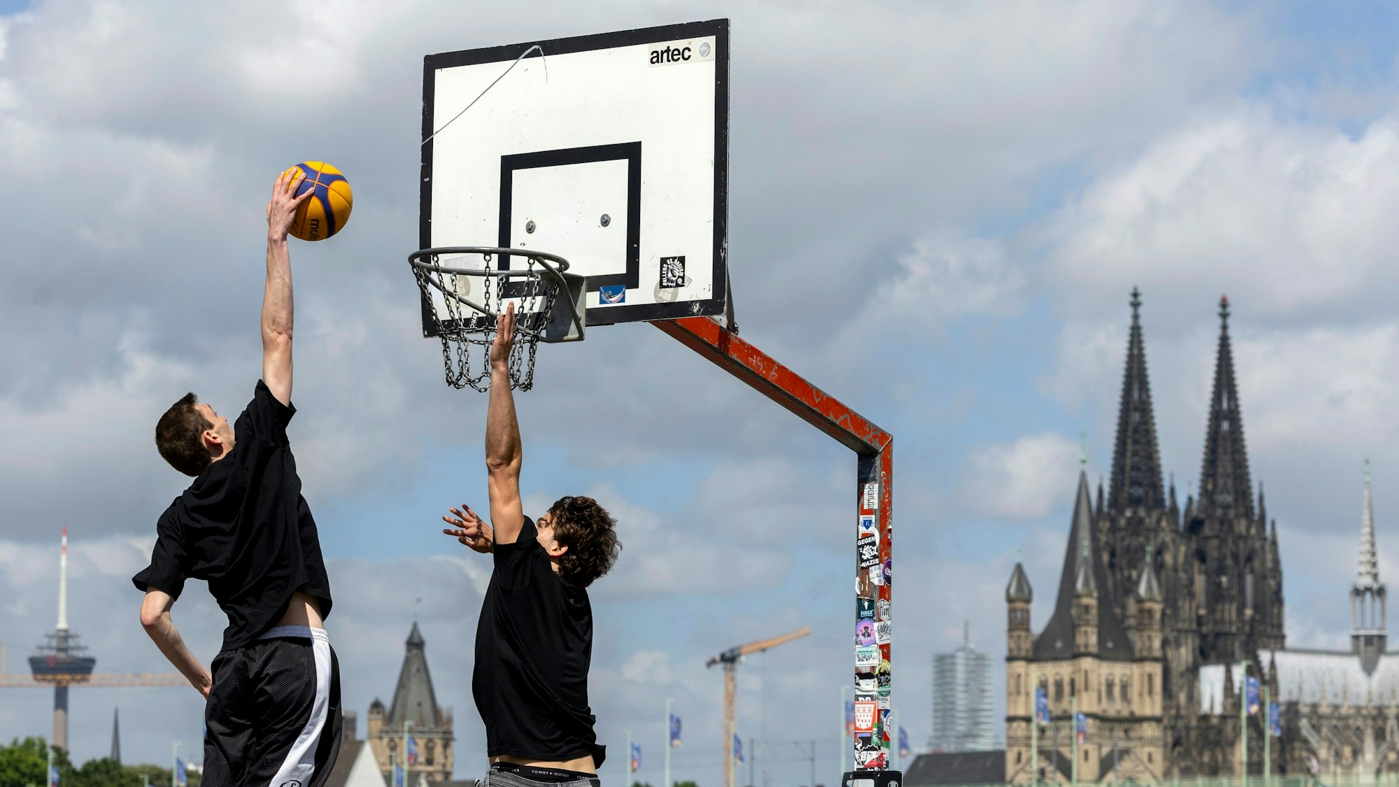Vorne der Dunk-Versuch, hinten der Kölner Dom: Eine 3x3-Partei auf der Deutzer Werft.