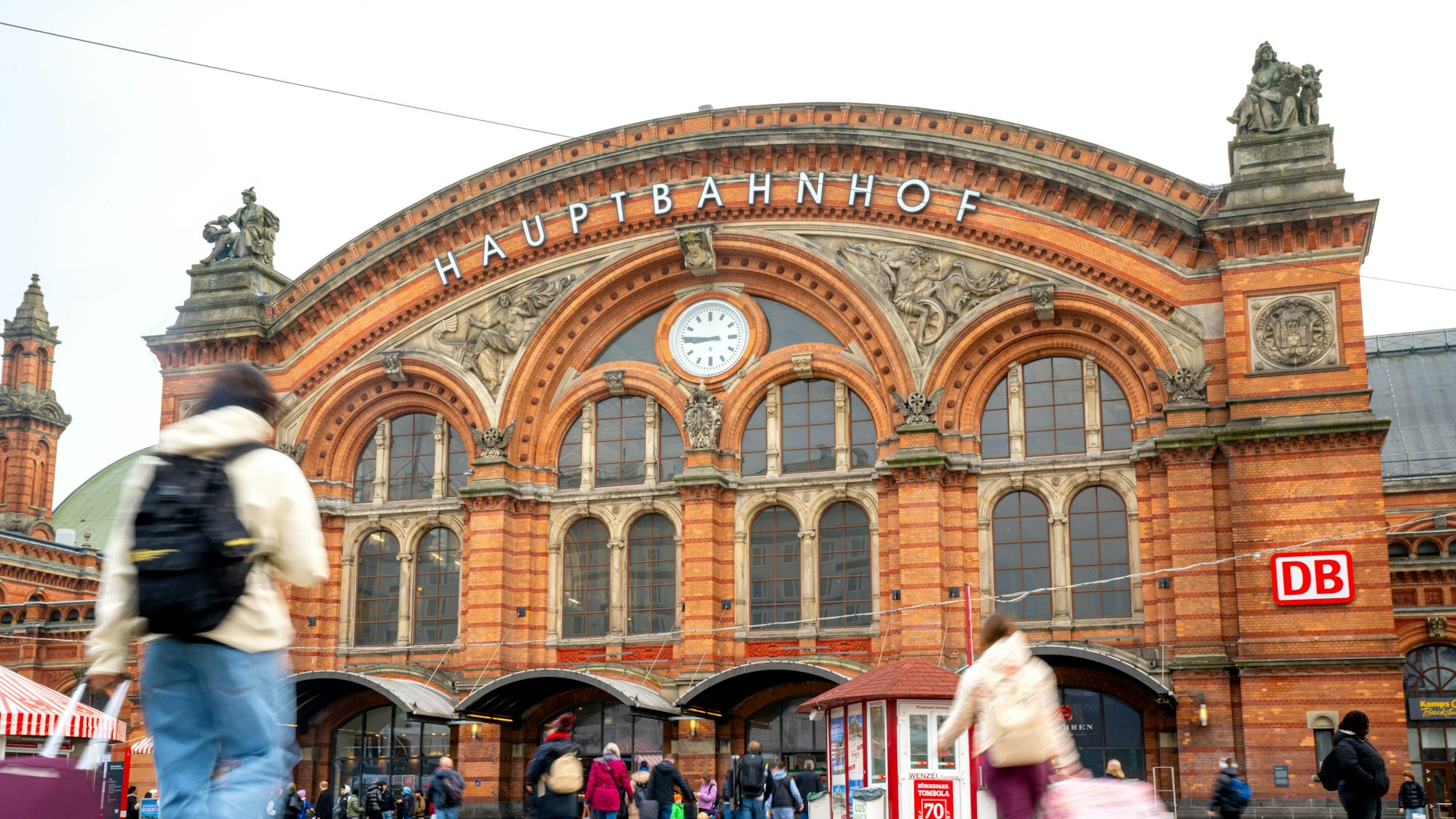 Reisende mit Koffern laufen zum Bremer Hauptbahnhof.