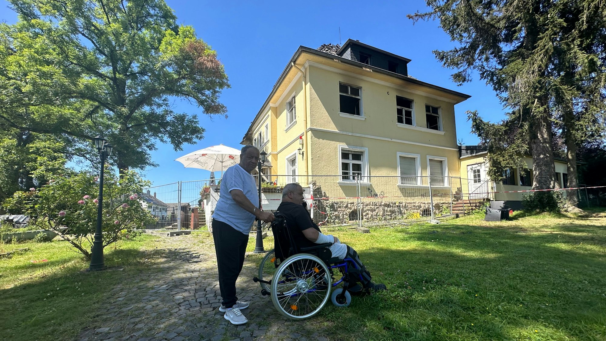Ayari Riathi kam direkt aus dem Krankenhaus zum Brandort. Sein Bruder Imed schiebt ihn. Beide sind in letzter Sekunden den Flammen entkommen.