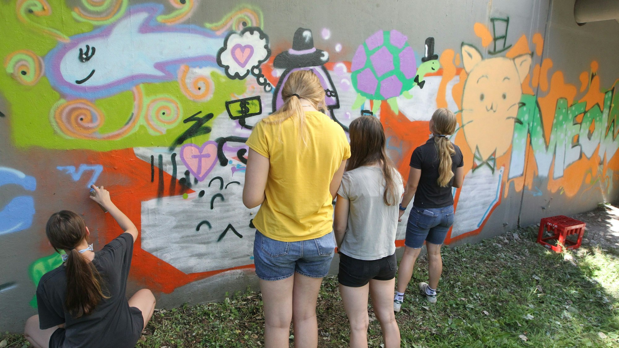 In ersten Sprayversuchen leben die Kids ihre Kreativität aus.