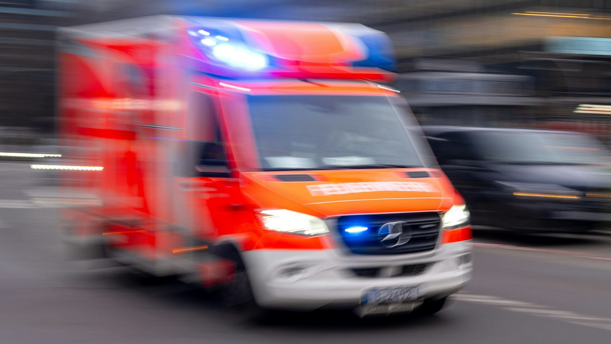 Ein Rettungswagen der Feuerwehr fährt mit Blaulicht zum Einsatz.