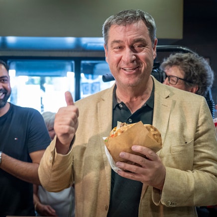 29.07.2024, Bayern, München: Markus Söder (CSU), Ministerpräsident von Bayern, holt sich in einem Dönerlokal einen frischen Döner an der Theke ab.