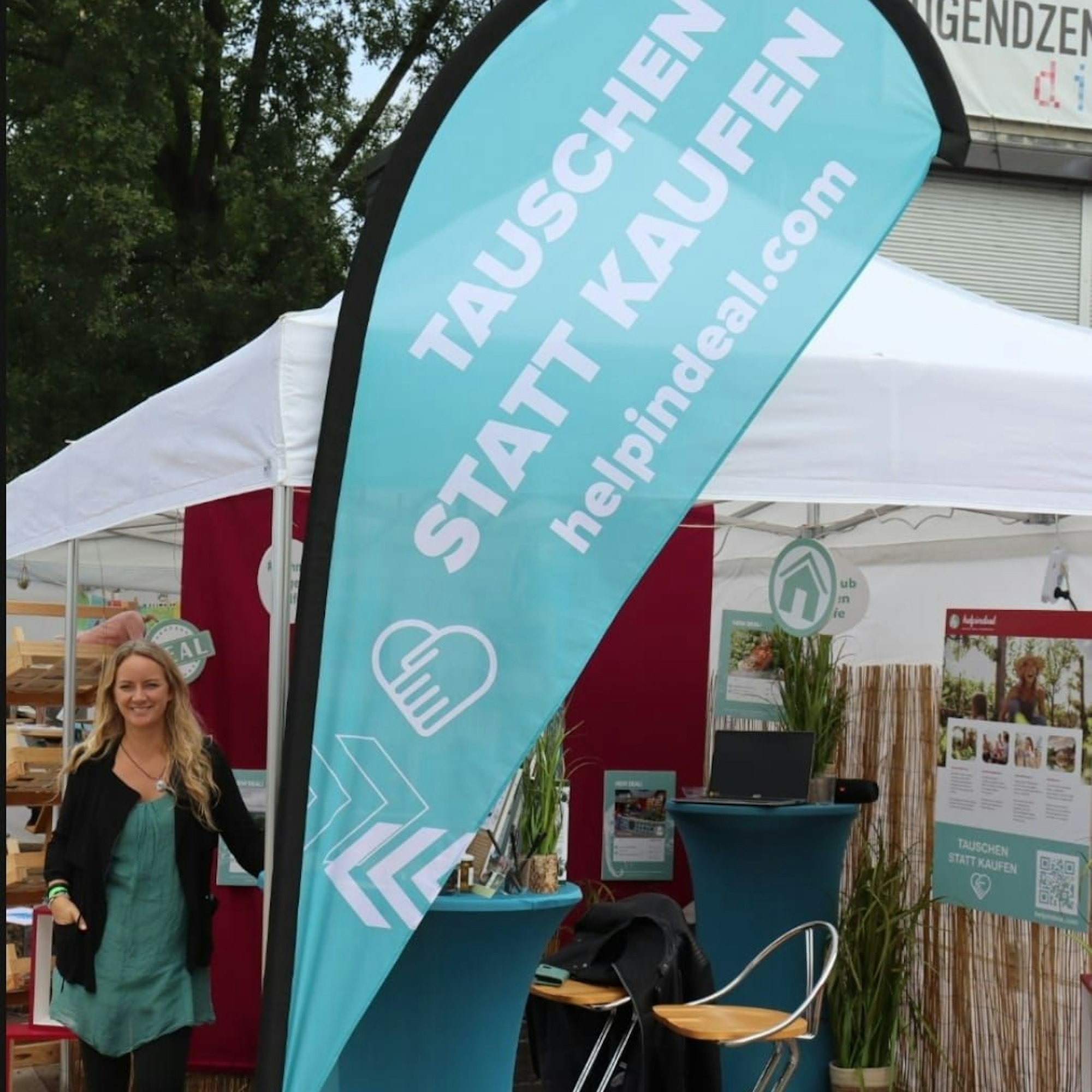 Cinja Christnacht steht neben einer Beachflag mit der Aufschrift „Tauschen statt kaufen“.