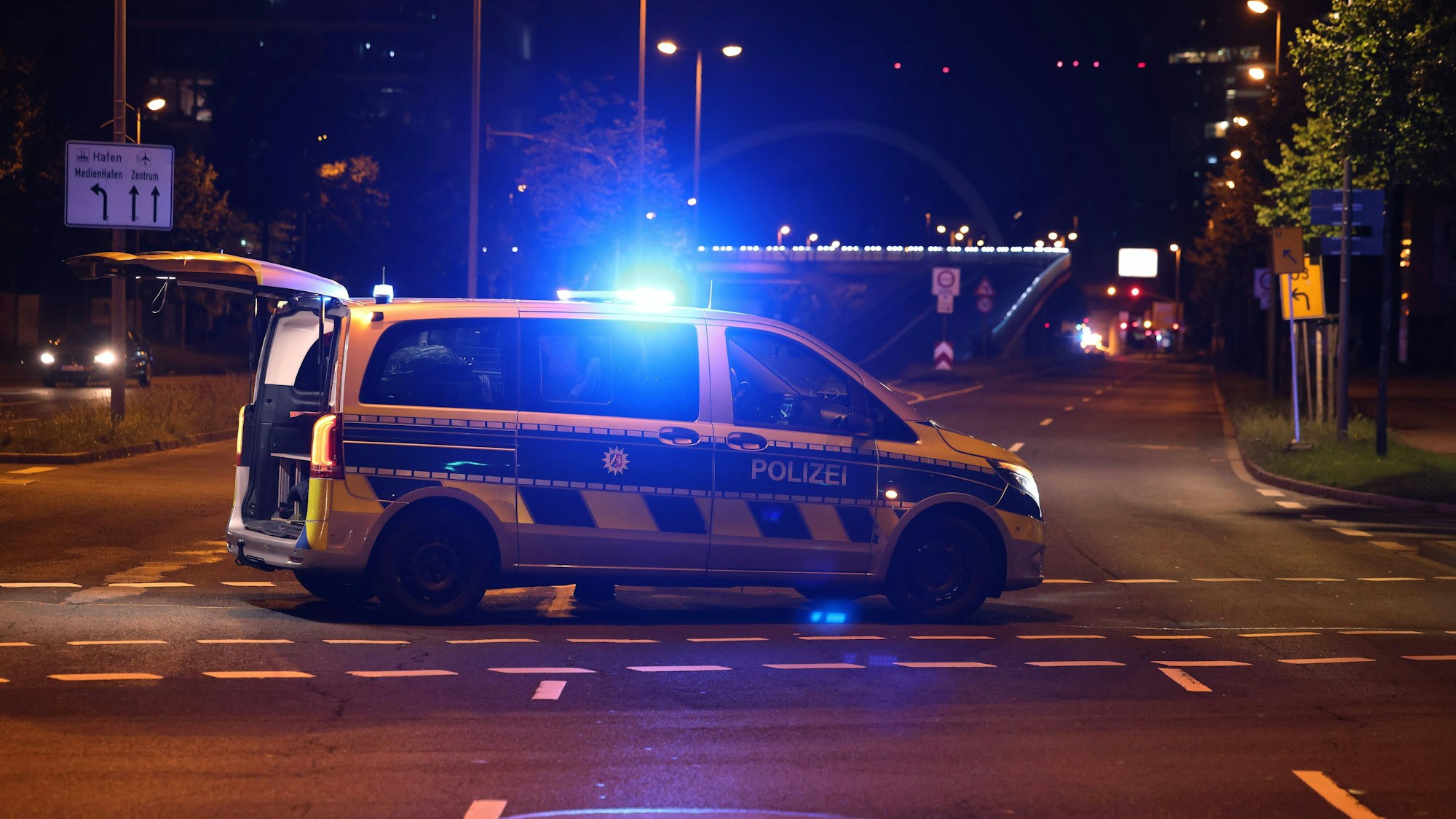 Polizeiauto steht in der Nacht mit Blaulicht auf einer Kreuzung