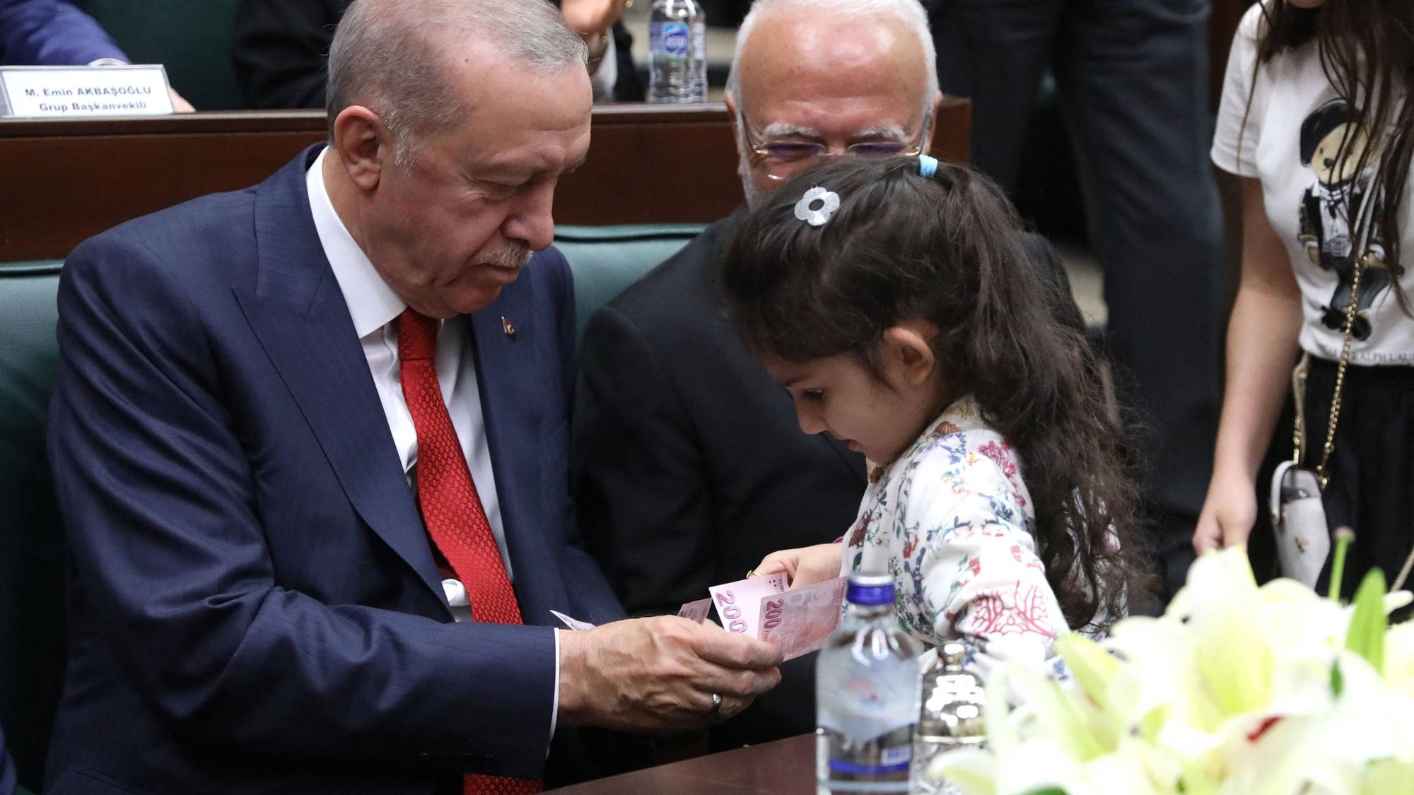 Recep Tayyip Erdogan gibt einem Mädchen einen Geldschein, nachdem dieses ihm die Hand geküsst hat (Archivfoto).