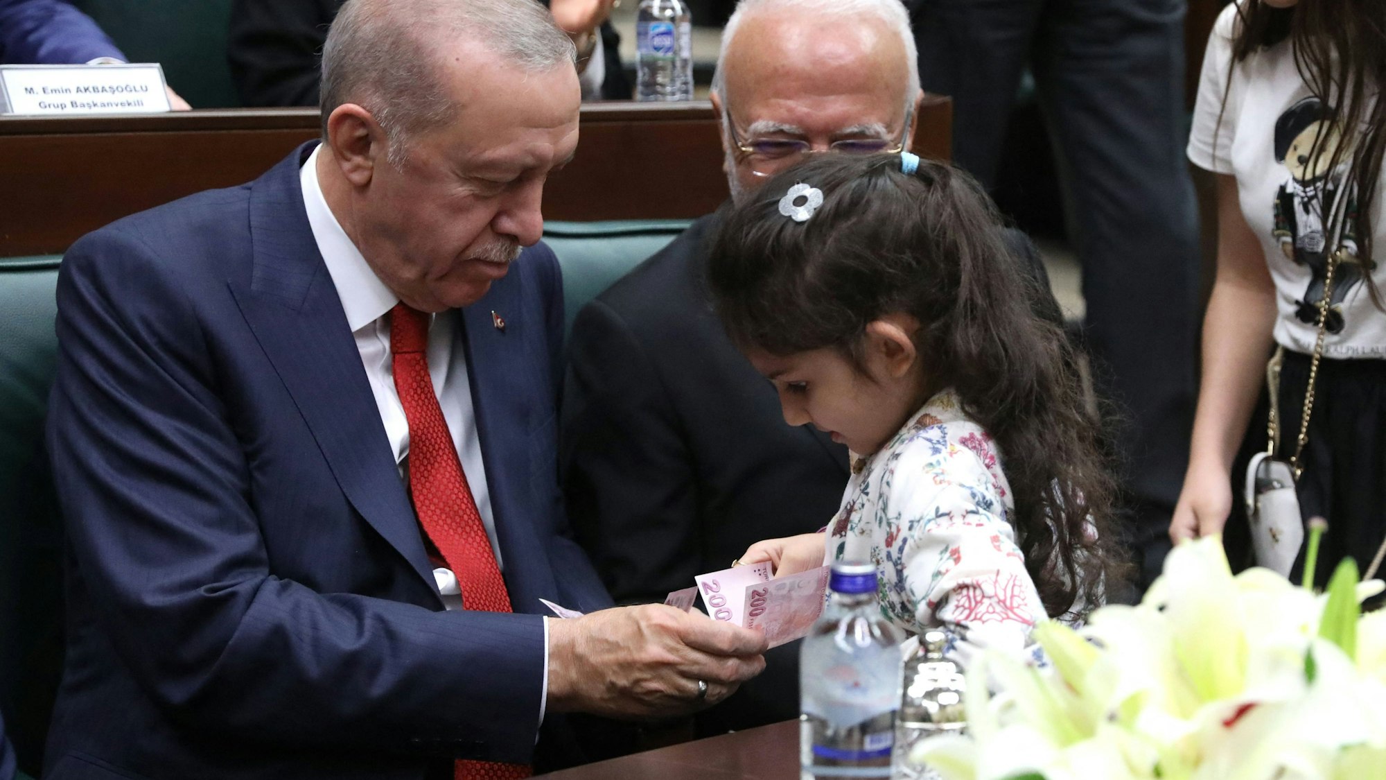 Recep Tayyip Erdogan gibt einem Mädchen einen Geldschein, nachdem dieses ihm die Hand geküsst hat (Archivfoto).