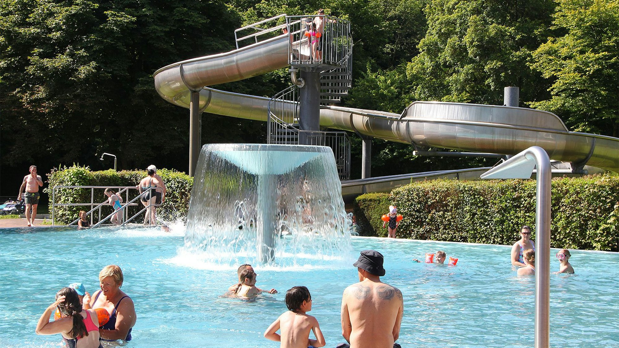 Im Schleidener Erlebnisbad Dieffenbachtal, das über eine Wasserrutsche verfügt, sind zahlreiche Menschen.