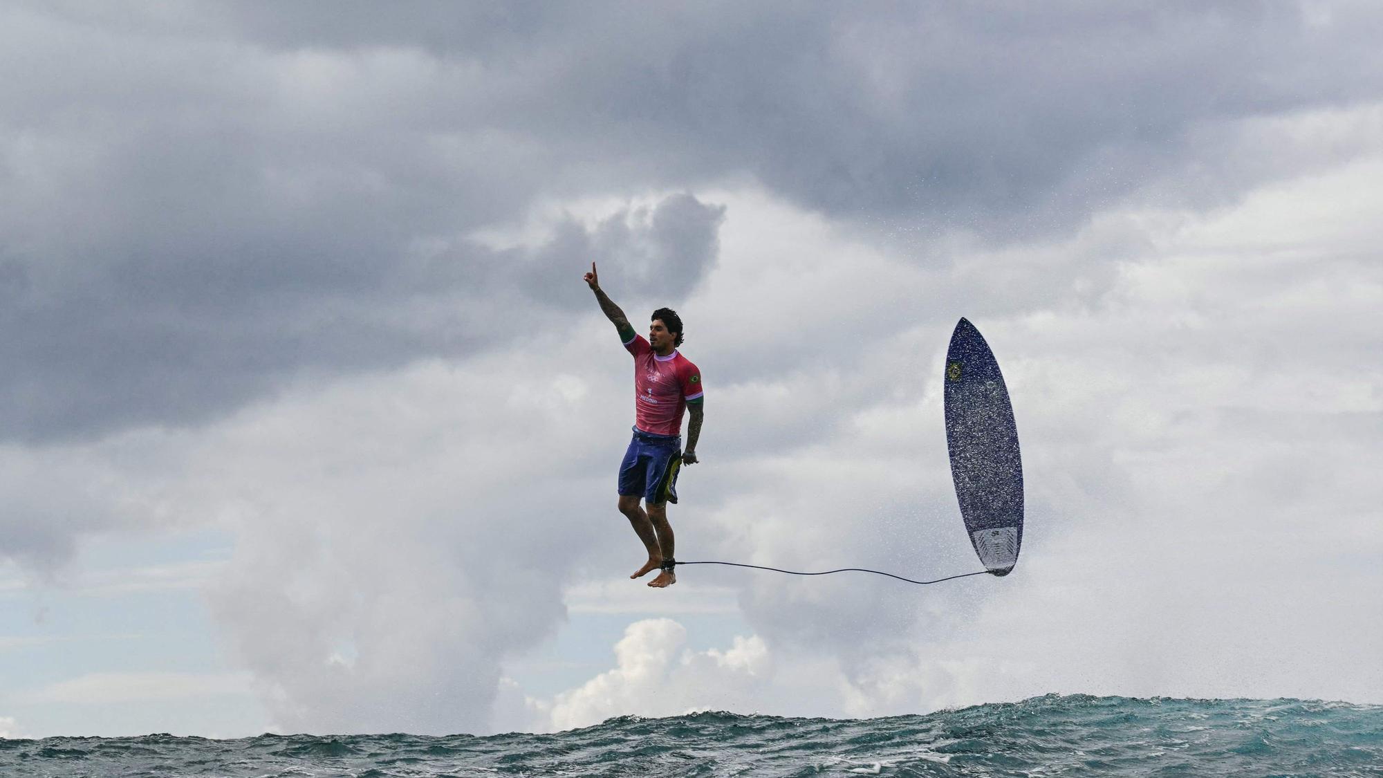 Der brasilianische Surfer Gabriel Medina während des Wettkampfes. Auf dem Bild sieht es so aus, als würde er grade in der Luft stehen, sein Surfboard fliegt neben ihm.