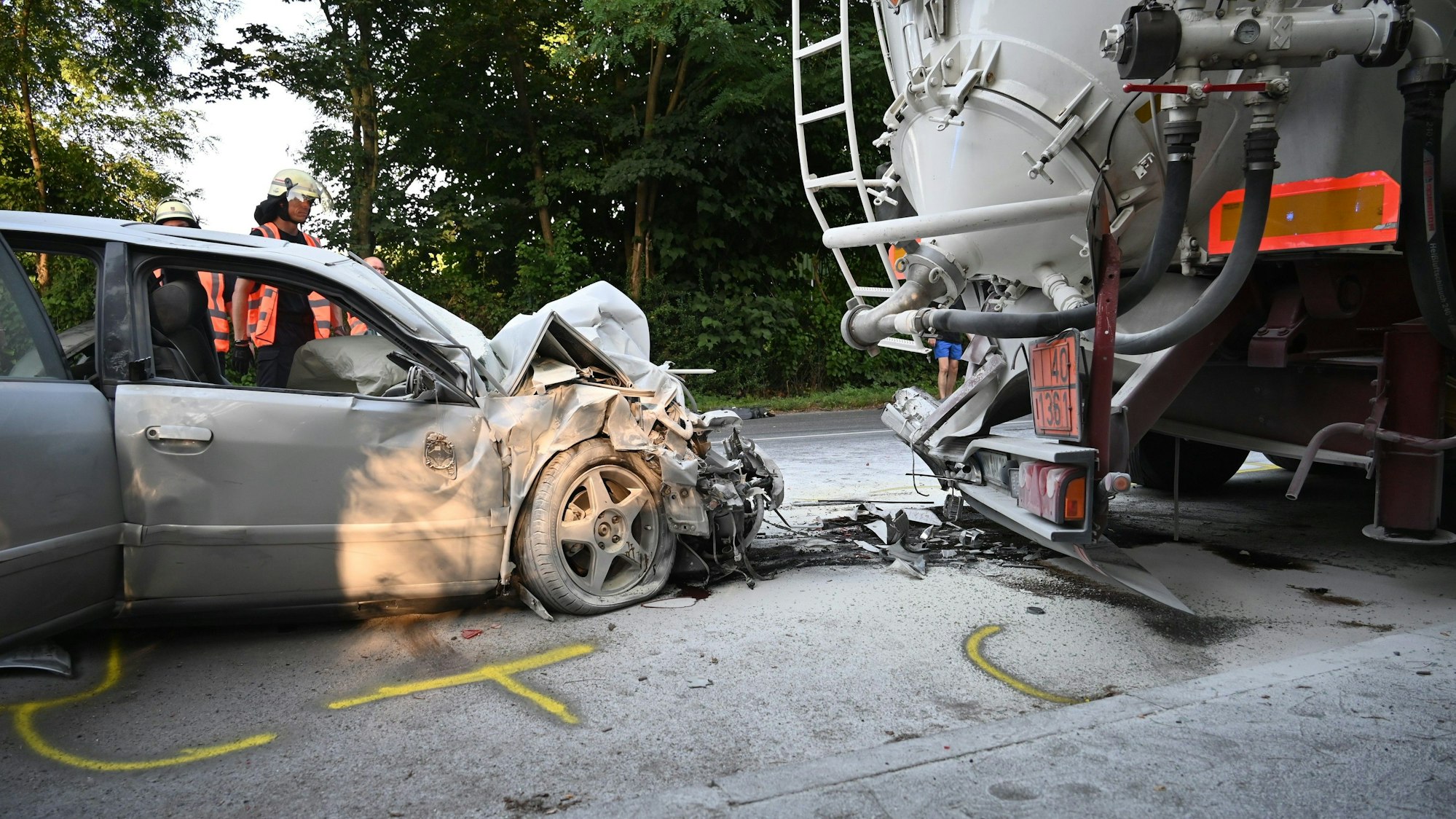 Ein zerstörter Wagen steht hinter einem Lkw.