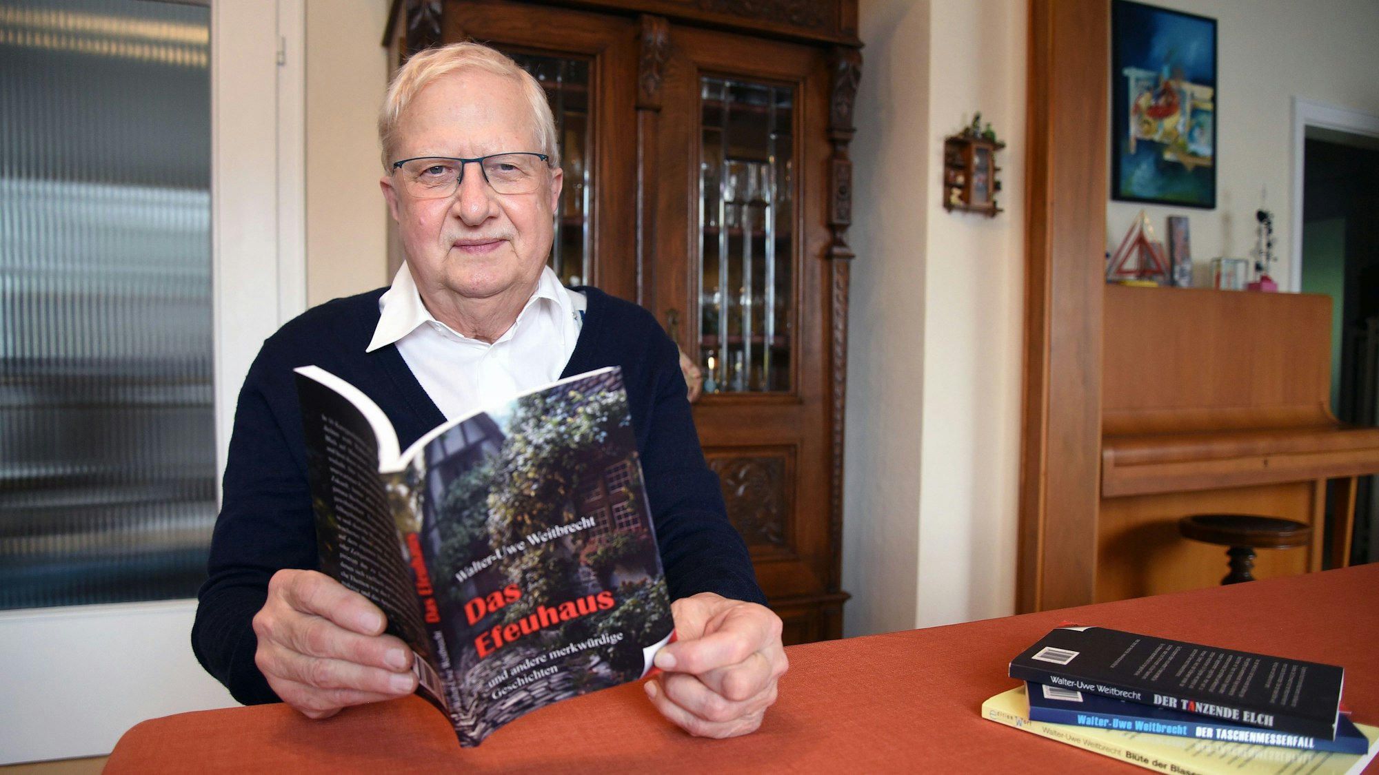 Das Foto zeigt den Autor Walter-Uwe Weitbrecht, in den Händen hält er sein neues Buch mit dem Titel  "Das Efeuhaus" .