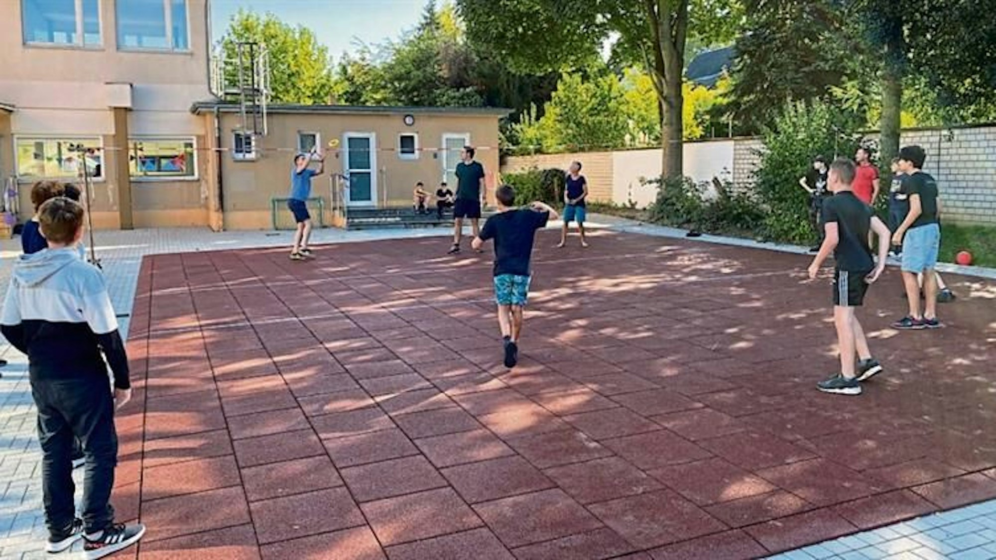 Jugendlich beim Ballspielen auf einem Schulhof.