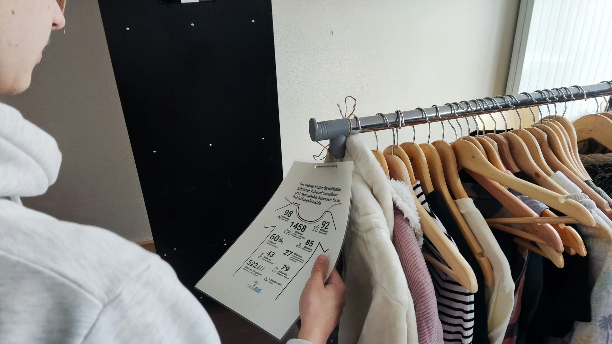 An einer Kleiderstange hängen verschiedene Oberteile.