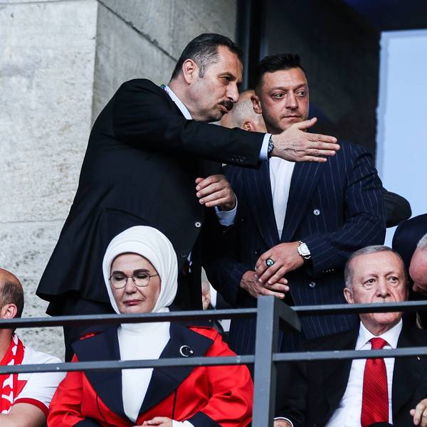 Ein Mann zeigt Mesut Özil seinen Platz auf der Ehrentribüne im Berliner Olympiastadion. Auch Recep Tayyip Erdogan und seine Frau sind zu sehen.
