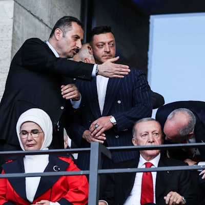 Ein Mann zeigt Mesut Özil seinen Platz auf der Ehrentribüne im Berliner Olympiastadion. Auch Recep Tayyip Erdogan und seine Frau sind zu sehen.
