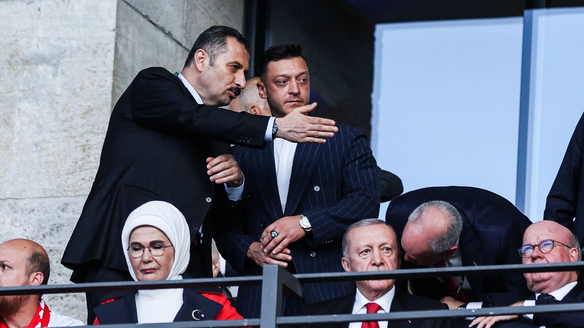 Ein Mann zeigt Mesut Özil seinen Platz auf der Ehrentribüne im Berliner Olympiastadion. Auch Recep Tayyip Erdogan und seine Frau sind zu sehen.