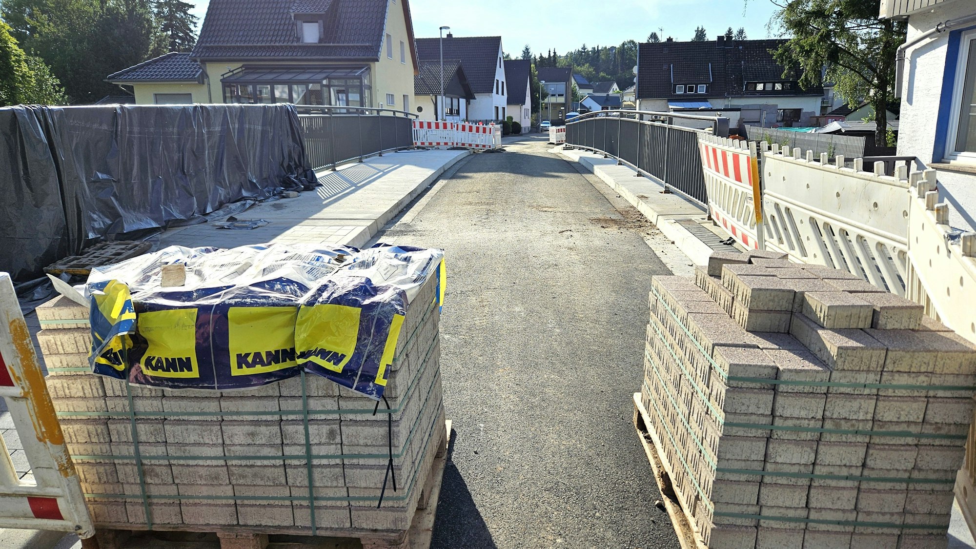 Paletten mit Pflastersteinen stehen vor der Zufahrt zu der neuen Brücke