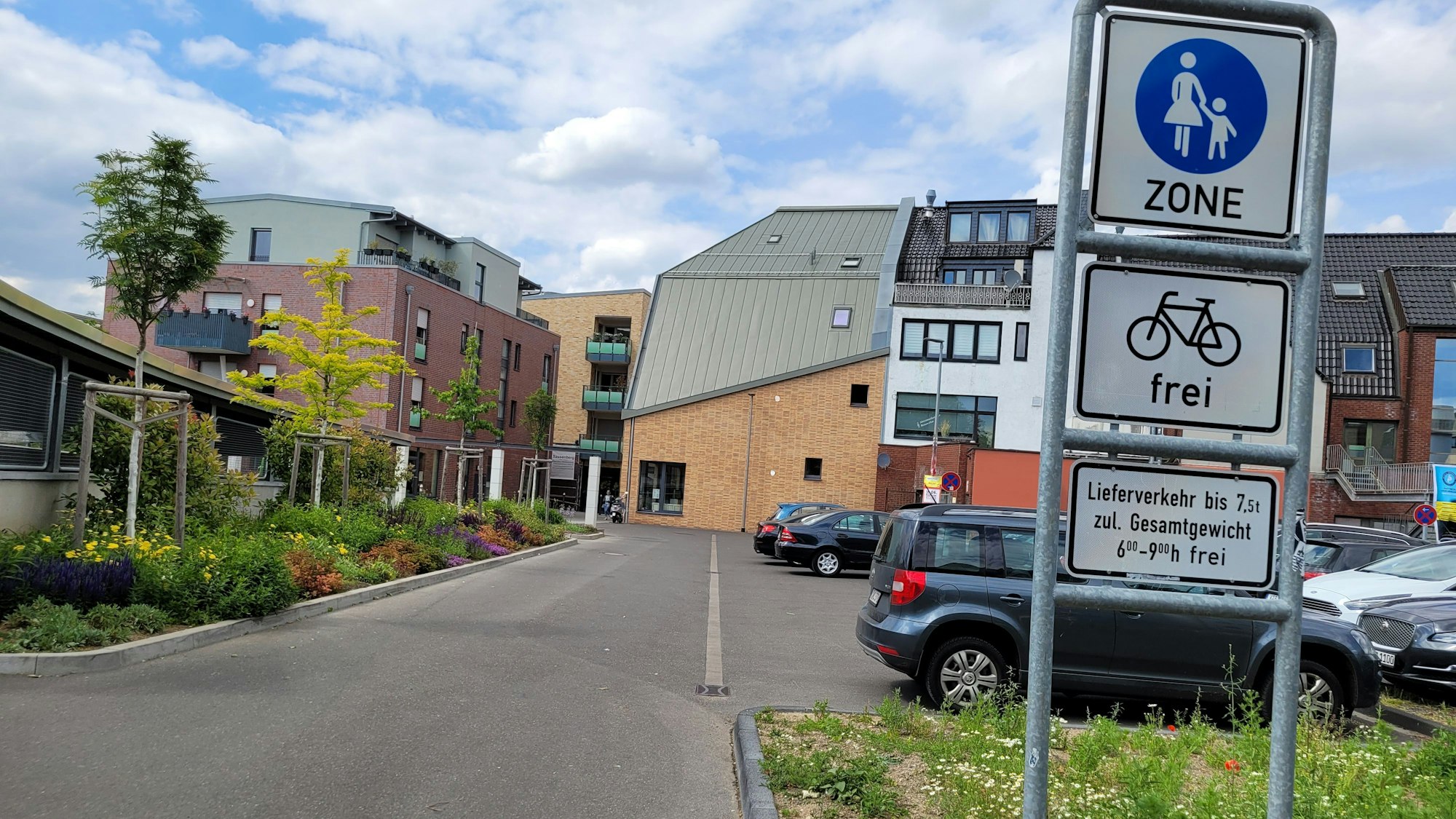 Schilder weisen auf eine Fußgängerzone hin, für Fahrräder ist sie frei. Hinter den Schildern parken Autos, was verboten ist.