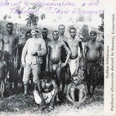Kolonialismus als Postkartenmotiv: Ein deutscher Siedler posiert für den Fotografen mit einheimischen Arbeitern in Kamerun