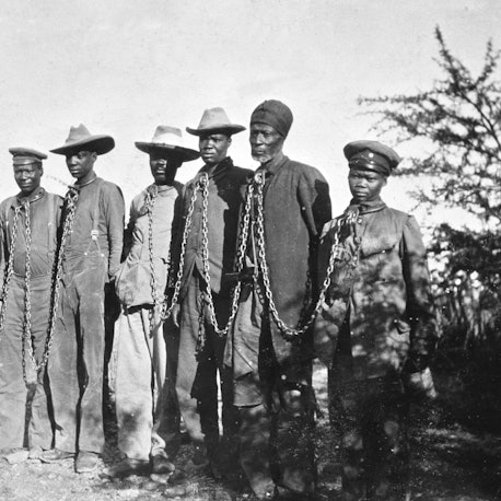 Sieben Männer der Herero in Ketten: Der Krieg im heutigen Namibia von 1904 bis 1908 gilt als erster Völkermord des 20. Jahrhunderts. Der deutsche Befehlshaber Lothar von Trotha hatte einen Vernichtungskrieg befohlen.