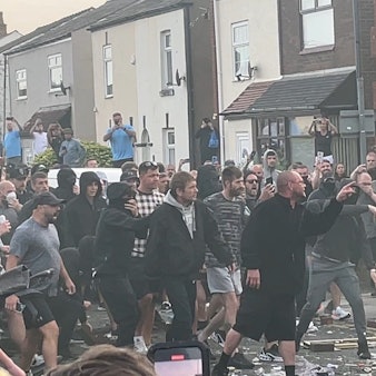 30.07.2024, Großbritannien, Southport: Menschen stoßen während Unruhen mit der Polizei zusammen, in der Nähe des Ortes, an dem am Vortag drei Mädchen bei einem Messerangriff getötet wurden.