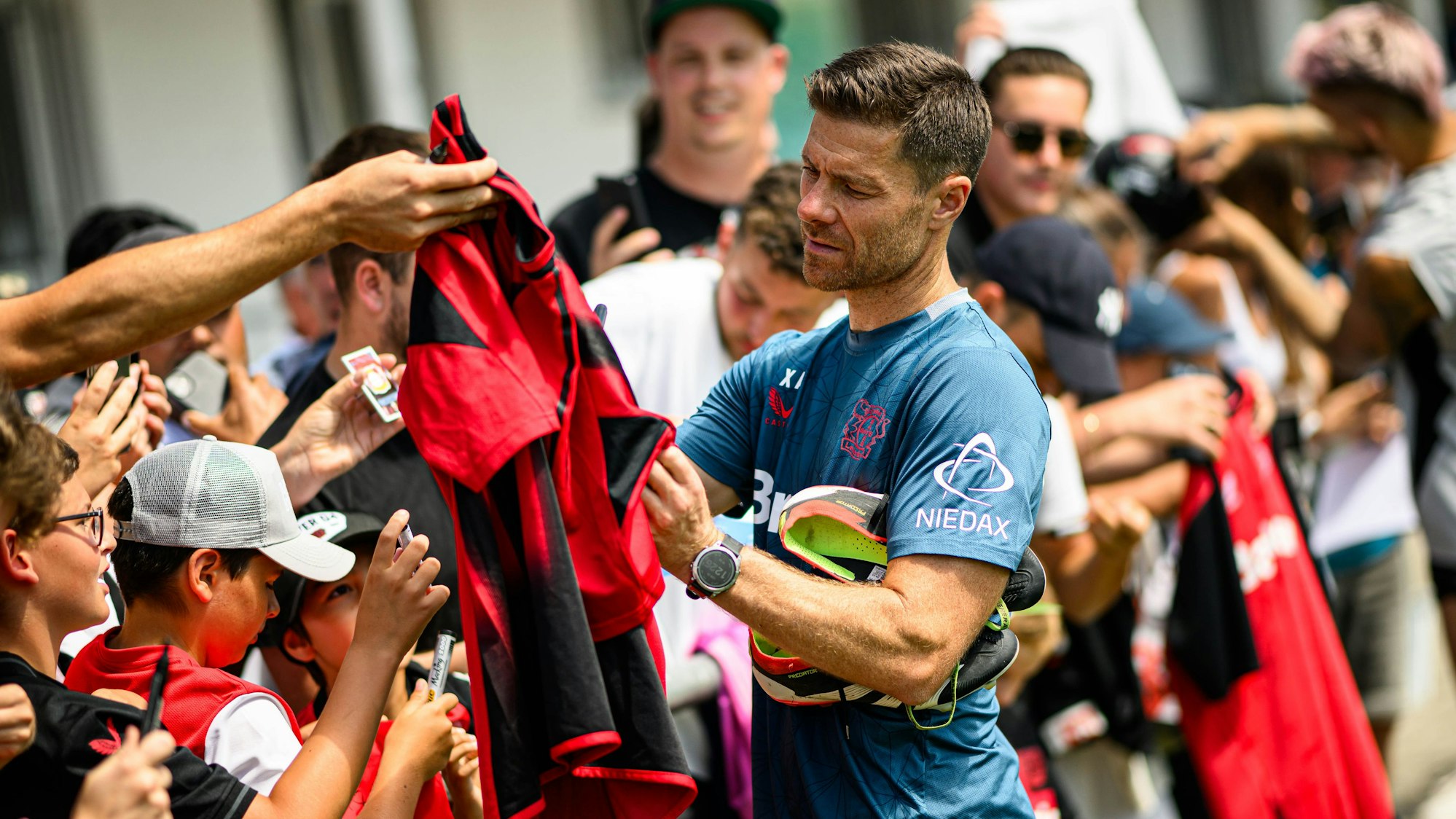 Xabi Alonso schreibt im Trainingslager von Bayer 04 Leverkusen in Donaueschingen Autogramme.