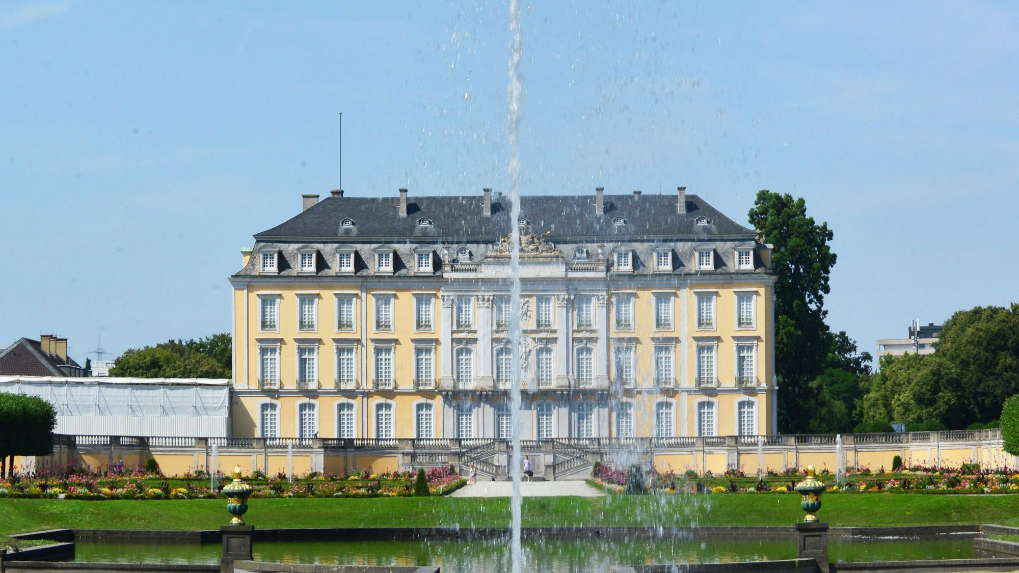 Zu sehen ist eine Wasserfontäne vor einem Schloss.