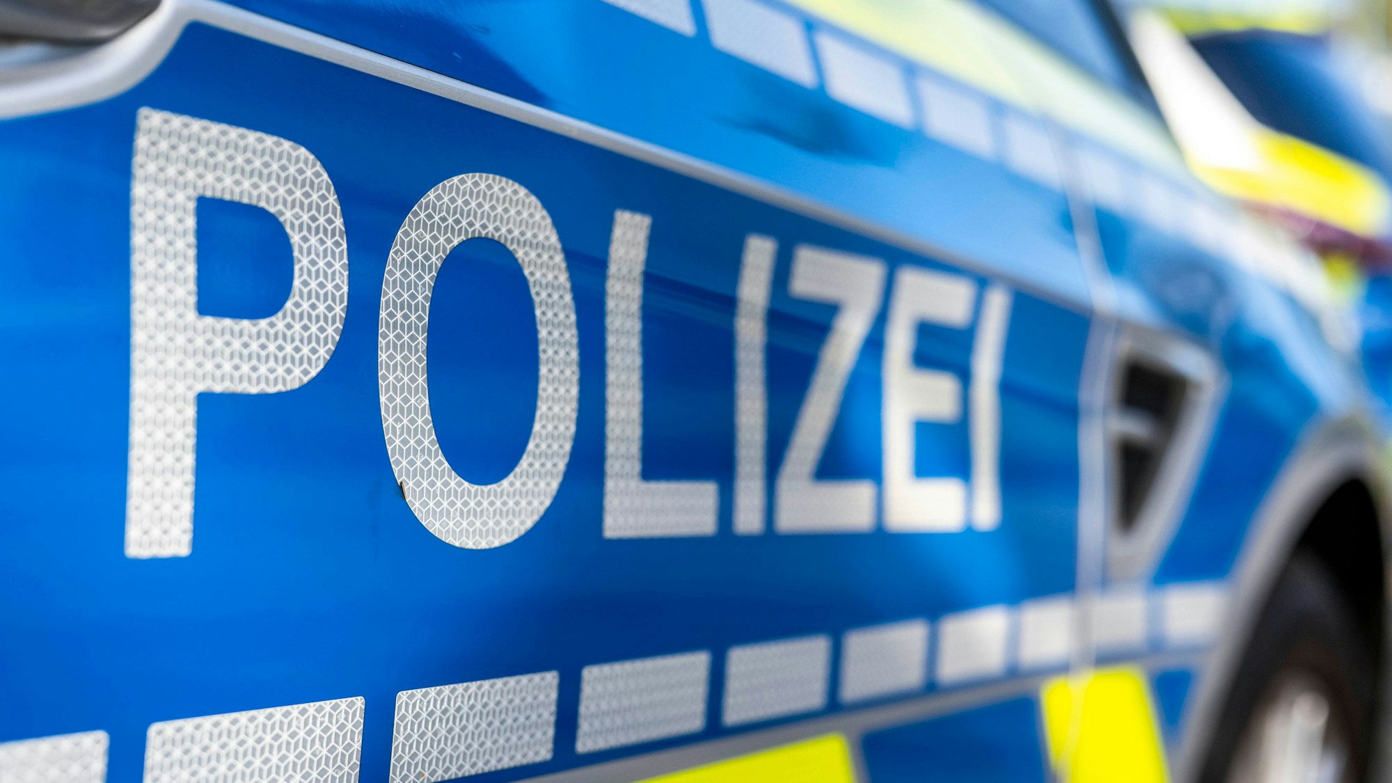 An der Tür von einem Streifenwagen steht der Schriftzug „Polizei“