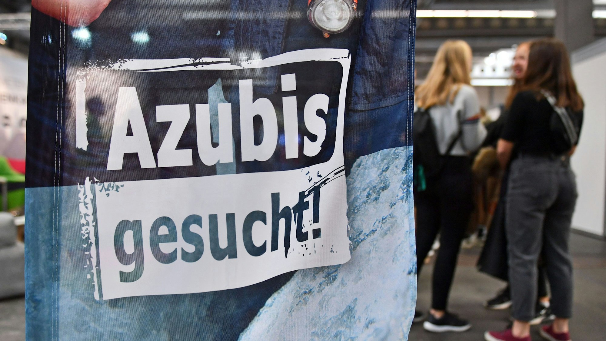 „Azubis gesucht“ steht auf einem Banner bei einer Berufsorientierungsmesse.