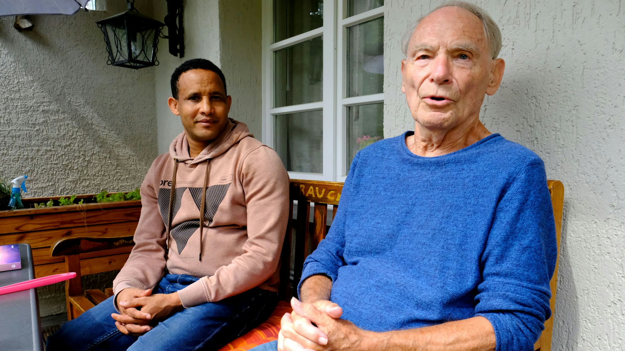 Dr. Herbert Kaefer, 86, sitzt mit seinem Adoptivsohn Tesfay auf dem Balkon seines Hauses am Gemünder Marienplatz.