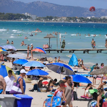 27.07.2024, Spanien, Muro: Menschen sonnen sich am Playa de Muro. Mallorca erwartet die erste Hitzewelle des Sommers. Foto: Clara Margais/dpa +++ dpa-Bildfunk +++