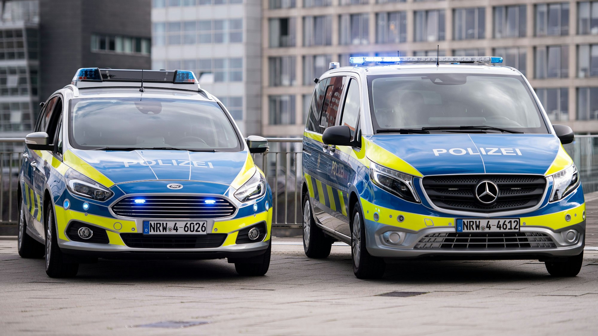 Neue Polizeiwagen vom Typ Mercedes Benz Vito (r) und Ford S-Max stehen im Düsseldorfer Medienhafen. (zu dpa: «NRW lässt 3000 ausgemusterte Polizeiautos versteigern») +++ dpa-Bildfunk +++