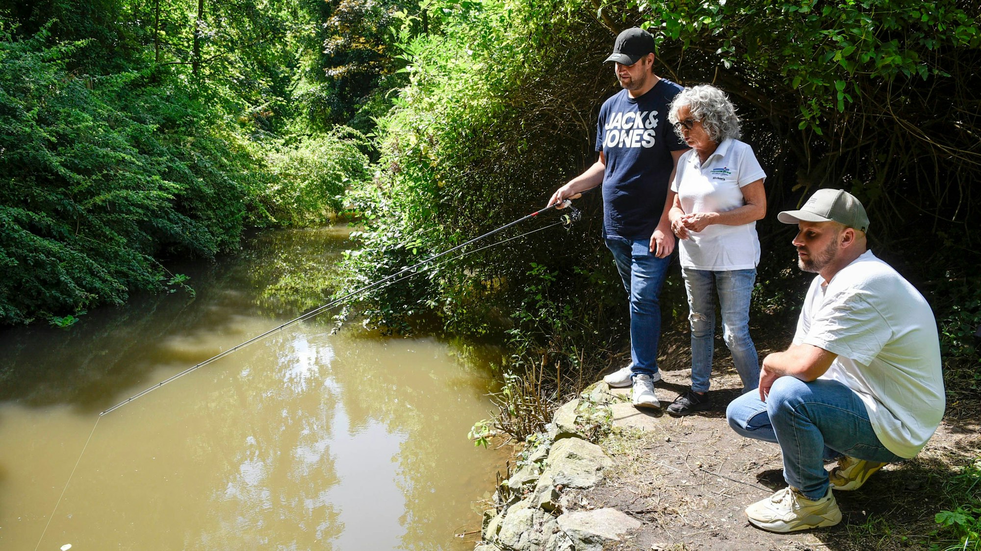 Gewässerwart Pascal Franzen hat an der Erft unmittelbar am Anglerheim seine Angel ausgeworfen, hier mit der Vorsitzenden Michaela Krumbach und Beisitzer Thomas Cygan.