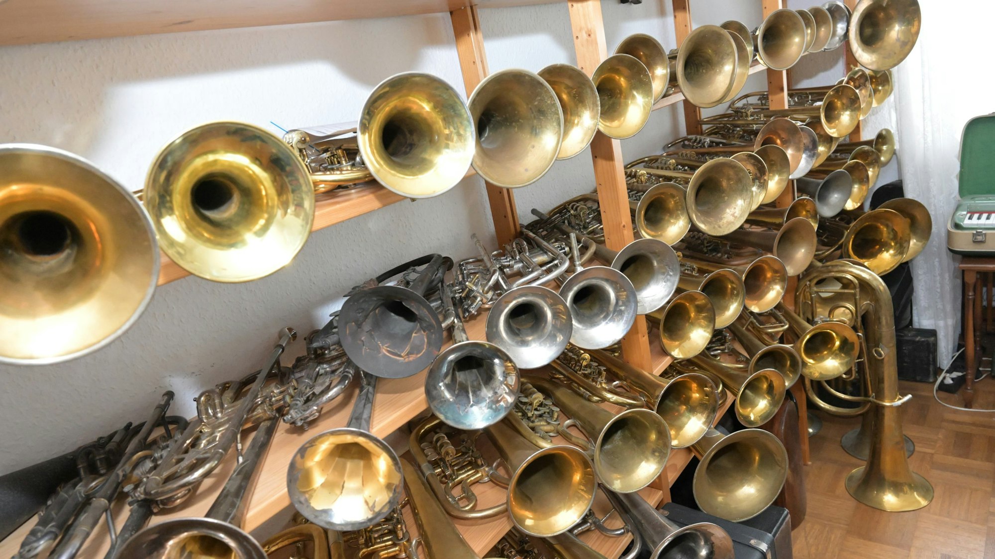 Trompeten liegen in Regalen.
