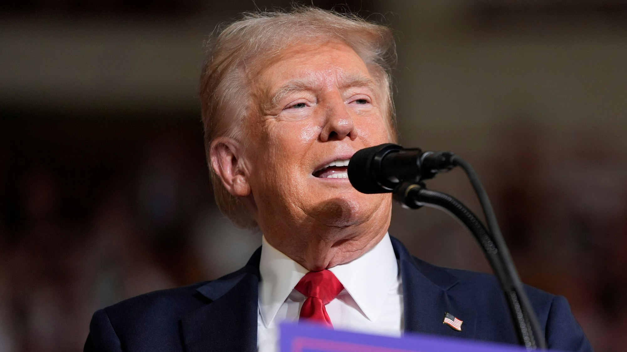 Der ehemalige US-Präsident Donald Trump steht bei einer Wahlkampfveranstaltung am Mikrofon und hält eine Rede vor seinen Anhängern.