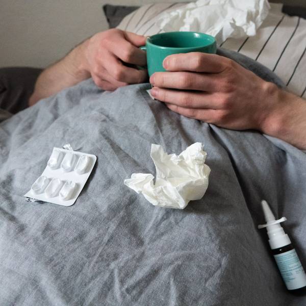 ILLUSTRATION - Ein Mann liegt mit Taschentüchern, Teetasse, Nasenspray und Tabletten im Bett (gestellte Szene). Derzeit bewegt sich die Rate akuter Atemwegserkrankungen in der Bevölkerung weiter auf einem relativ hohen Niveau im Vergleich zu früheren Jahren. +++ dpa-Bildfunk +++