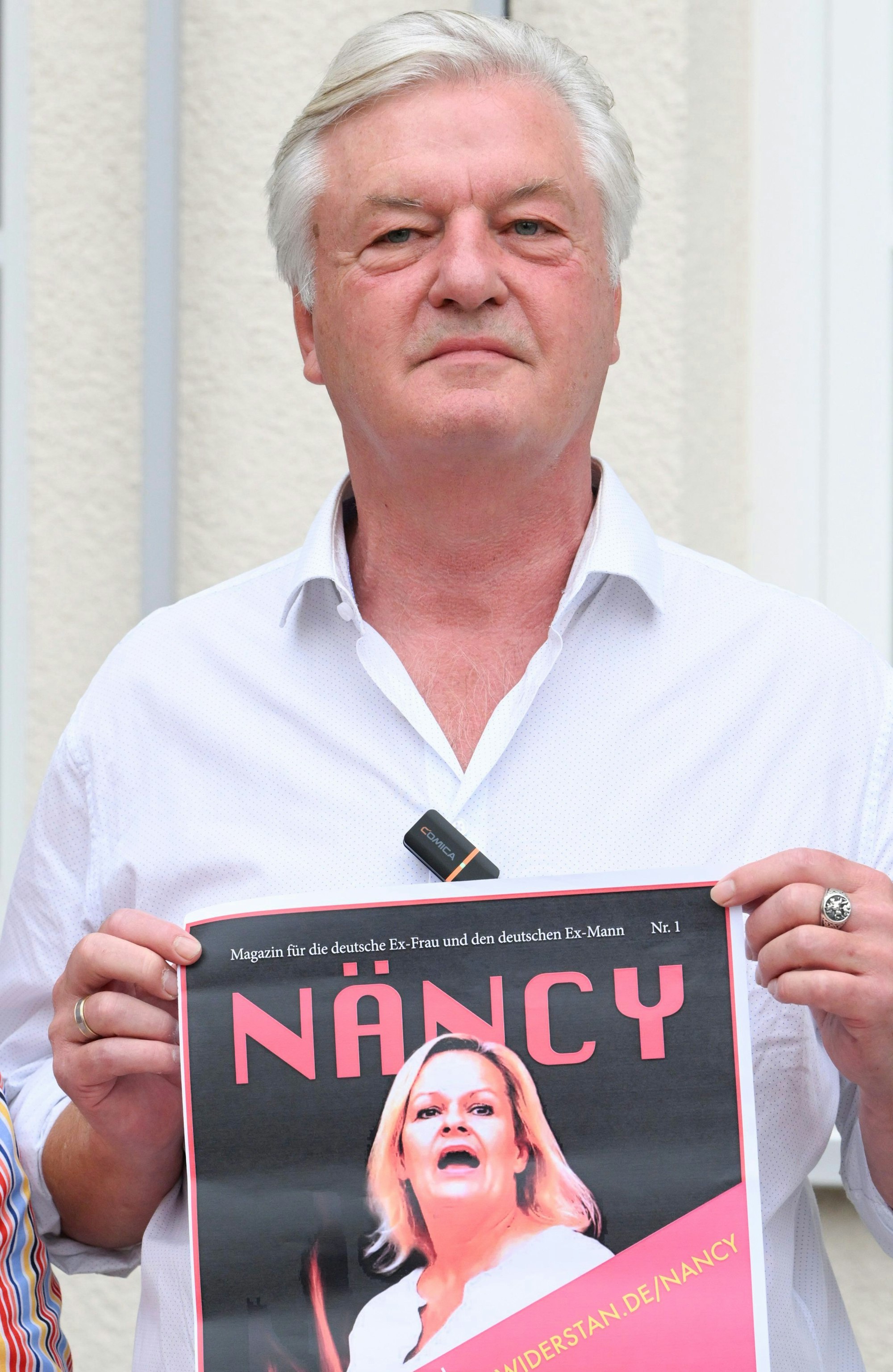 31.07.2024, Brandenburg, Falkensee: Jürgen Elsässer, Chefredakteur des verbotenen Magazins Compact, hält bei einer Spontandemonstration nach einer Pressekonferenz im Musiksaal Falkensee das Cover einer Internetpublikation in den Händen. Hier werden die Inhalte aus dem verbotenen «Compact»-Magazins veröffentlicht. Foto: Jens Kalaene/dpa +++ dpa-Bildfunk +++