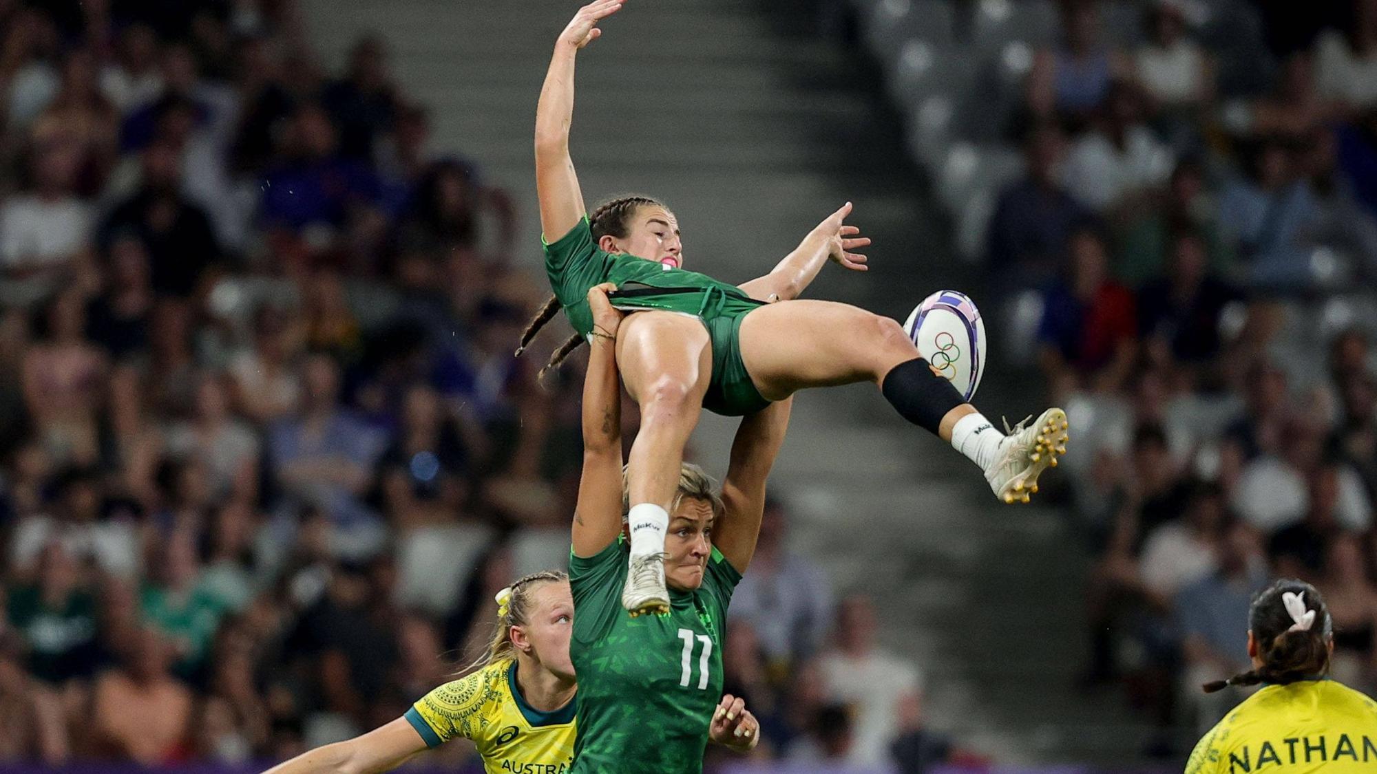 Emily Lane hebt andere Spielerin in die Luft.