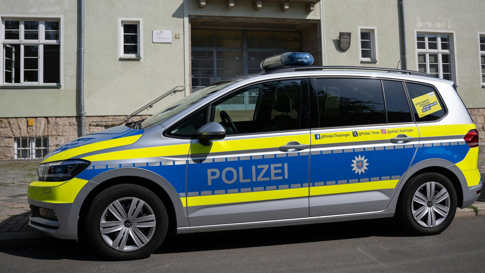 Ein Polizeiwagen steht vor der Heinrich-Mann-Gymnasium in Erfurt.