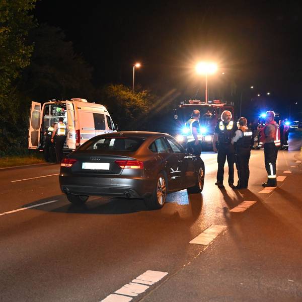Auf dem Foto ist die Unfallstelle zu sehen. Der Unfallwagen steht auf der Straße. Zu sehen sind Polizisten und Rettungskräfte.