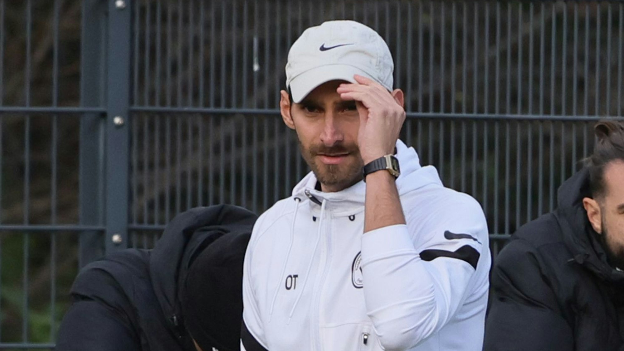 Es man fasst sich an seine Kappe.