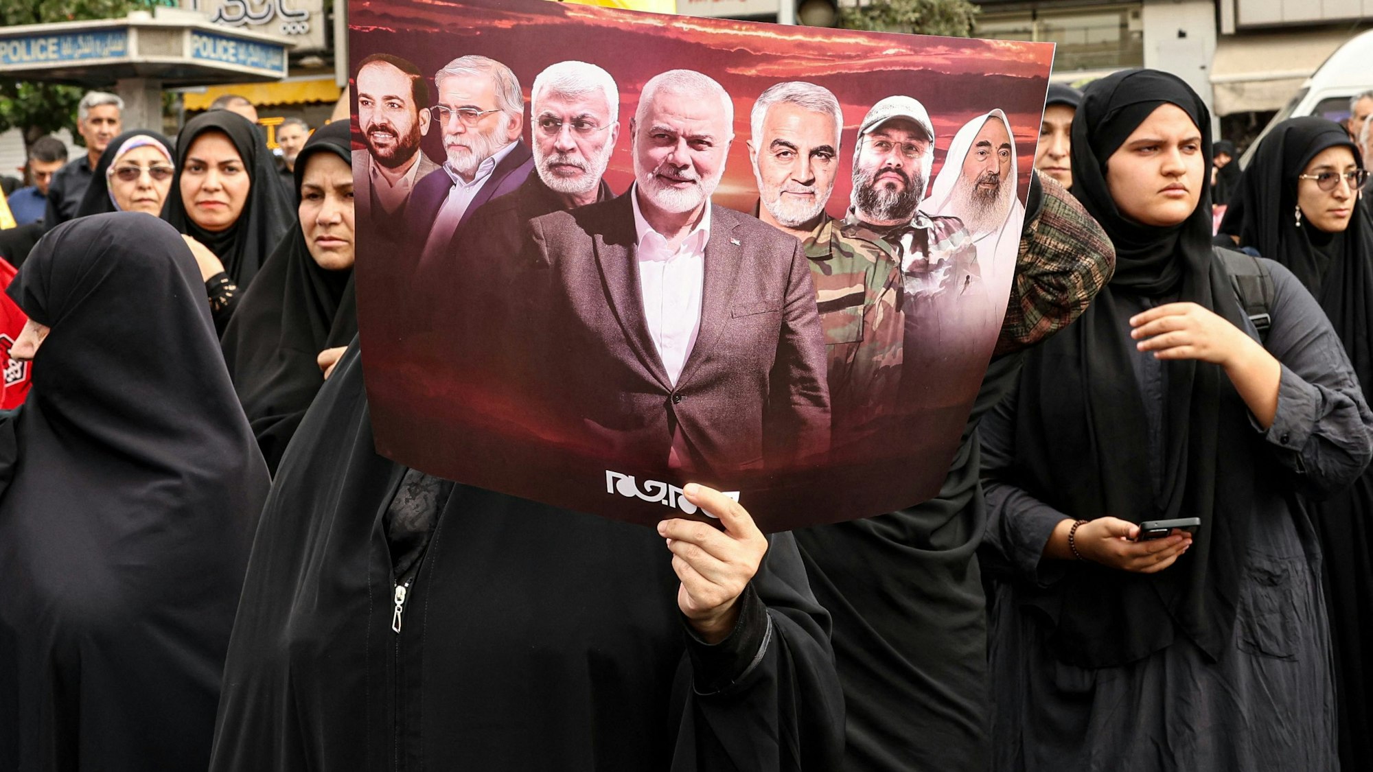 Eine iranische Frau hält ein Plakat,
